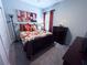 Bright bedroom with floral bedding, window with curtains, and a dresser at 6855 Mossy Oak Ln, Lakeland, FL 33810