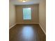 Bright bedroom with wood-look floors and large window at 3314 Robert Trent Jones Dr # 30801, Orlando, FL 32835