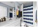 Clean bathroom with a striped shower curtain and a mirror at 2986 Sw 143Rd Place Rd, Ocala, FL 34473