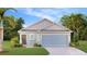 Attractive single-story home with light blue exterior, two-car garage, and landscaped lawn at 5822 Le Marin Way, Kissimmee, FL 34758