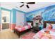 Bedroom with twin beds, ensuite bathroom, and Moana mural at 7650 Fairfax Dr, Kissimmee, FL 34747