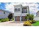 Two-story house with a two-car garage, balcony, and landscaping at 7650 Fairfax Dr, Kissimmee, FL 34747