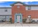 Brick building exterior with a teal door and landscaping at 7340 Daniel Webster Dr # 6, Winter Park, FL 32792