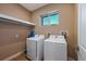 Bright laundry room with washer, dryer, and overhead shelving at 7482 Brooklyn Dr, Kissimmee, FL 34747