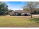 Single-story house with a large yard, attached garage, and driveway at 4995 County Road 121D, Wildwood, FL 34785