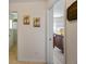 Clean hallway with artwork and view into a bedroom at 4995 County Road 121D, Wildwood, FL 34785