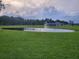 Tranquil pond with a fountain, surrounded by lush green grass and trees at 11643 Us Highway 98 N, Lakeland, FL 33809