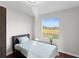 Bright bedroom with a single bed, large window, and wood floors at 7435 Postal Colony Rd, Clermont, FL 34714