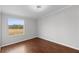 Simple bedroom with wood floors and large window at 7435 Postal Colony Rd, Clermont, FL 34714