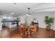 Dining room with kitchen view, wood floors, and a farmhouse table at 7435 Postal Colony Rd, Clermont, FL 34714