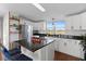 Modern kitchen with white cabinets, granite island and stainless steel appliances at 7435 Postal Colony Rd, Clermont, FL 34714