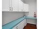 Laundry room with white cabinets and teal countertop at 7435 Postal Colony Rd, Clermont, FL 34714