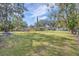 Large backyard with lush grass and mature trees at 1030 Pineview Pl, Lakeland, FL 33801