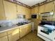 View of kitchen with wood cabinets, appliances, and tiled floors at 4805 Sand Mountain Loop Rd, Auburndale, FL 33823