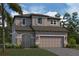 Two-story house with gray siding, light teal door, and a two-car garage at 4897 Foxglove Dr, Lakeland, FL 33811