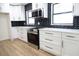 Modern kitchen with white cabinets, stainless steel appliances, and herringbone backsplash at 3203 S Polk Ave, Lakeland, FL 33803