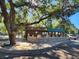 Log cabin home with green metal roof, stone wall, and spacious patio at 25232 Ne 142Nd St, Fort Mc Coy, FL 32134