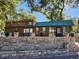 Log cabin with green metal roof and stone retaining wall at 25232 Ne 142Nd St, Fort Mc Coy, FL 32134