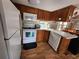 White appliances and wood cabinets in galley kitchen at 25232 Ne 142Nd St, Fort Mc Coy, FL 32134