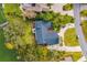An aerial view showcasing the home's unique roofline, backyard patio, and proximity to the water at 1212 Lake Point Dr, Lakeland, FL 33813