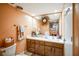 Bathroom with wood-like vanity, mirror, and decorative wreath at 1212 Lake Point Dr, Lakeland, FL 33813