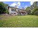 Exterior view of the two-story home with a deck, lawn, and surrounding trees at 1212 Lake Point Dr, Lakeland, FL 33813