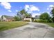 Charming home with a circular driveway, lush landscaping, and mature trees at 1212 Lake Point Dr, Lakeland, FL 33813