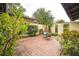 Private brick patio area with seating surrounded by lush landscaping at 1212 Lake Point Dr, Lakeland, FL 33813