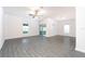 Open living room with grey wood-look floors and sliding glass doors to backyard at 13477 Leaping Water Way, Astatula, FL 34705