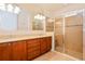 Bathroom featuring dual sinks, wood vanity, large mirror, and glass-enclosed shower at 1423 Harbor Ridge Dr, Poinciana, FL 34759