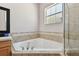 Corner soaking tub with shower in a tiled bathroom at 8915 Pinecrest Dr, Lakeland, FL 33809