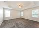 A comfortable bedroom with gray carpeting and multiple windows providing natural light at 5638 Cedar Waxwing Dr, The Villages, FL 32163