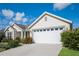 Exterior view of the single-story home featuring a white garage door and neat landscaping at 5638 Cedar Waxwing Dr, The Villages, FL 32163