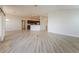 View of the open living area with wood-look flooring, showing the adjacent kitchen and dining space at 5638 Cedar Waxwing Dr, The Villages, FL 32163