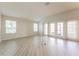 Spacious living room with wood-look flooring and large windows providing ample natural light at 5638 Cedar Waxwing Dr, The Villages, FL 32163