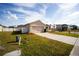 Tan house with a two-car garage and a white fence at 1046 Roberta Rd, Lake Wales, FL 33853