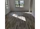 Bright living room featuring new wood-look flooring and large windows at 6611 Hereford Dr, Lakeland, FL 33810