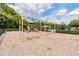 playground featuring swings, a slide, and surrounding trees at 2024 Capri Ln, Mount Dora, FL 32757