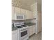 Kitchen with white cabinets, gas range, and microwave at 3323 Songbird Ln, Lakeland, FL 33811