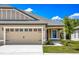 Tan house with gray roof, two-car garage, and landscaped front yard at 3216 Seville St, Lake Alfred, FL 33850