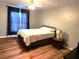 Bedroom with queen bed, wood-look floors, and large window at 169 Vista View Ave, Eagle Lake, FL 33839