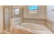 Bathroom with soaking tub, shower, and neutral tile at 1369 Palmetto Dunes St, Davenport, FL 33896