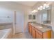 Bathroom with double vanity, granite countertop, and soaking tub at 1369 Palmetto Dunes St, Davenport, FL 33896