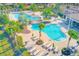 Community pool with lounge chairs and umbrellas at 1369 Palmetto Dunes St, Davenport, FL 33896