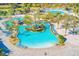 Aerial view of a large community pool with winding lazy river at 1369 Palmetto Dunes St, Davenport, FL 33896