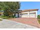 House exterior with two-car garage and brick driveway at 1369 Palmetto Dunes St, Davenport, FL 33896