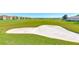 Sand trap on a lush green golf course with homes and landscape in the background at 1369 Palmetto Dunes St, Davenport, FL 33896