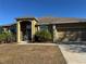 Exterior view of a house with a two-car garage and mature landscaping at 3483 Patterson Heights Dr, Haines City, FL 33844