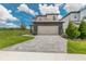 Inviting two-story home with a paved driveway, stone accents, and a two-car garage at 7837 Somersworth Dr, Kissimmee, FL 34747