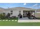 Private backyard featuring a screened-in porch, patio area, and lush artificial turf at 1767 Bee Nice Dr, Kissimmee, FL 34744